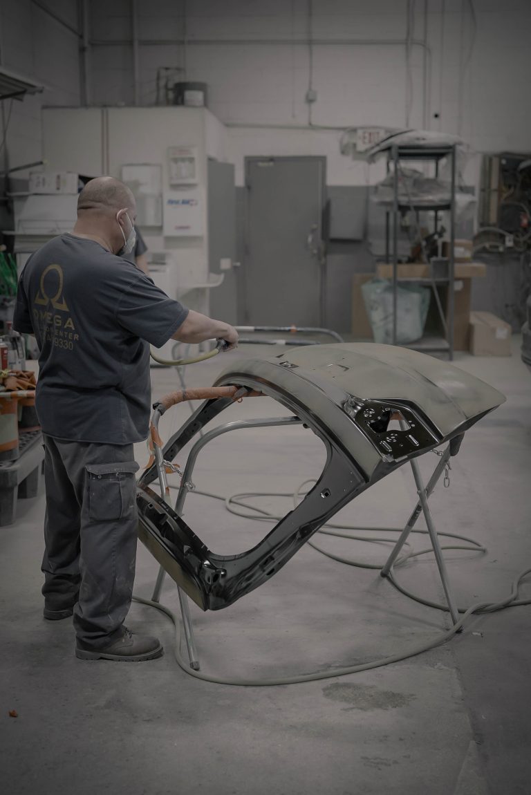 Omega Collision Center technician preparing a vehicle body panel
